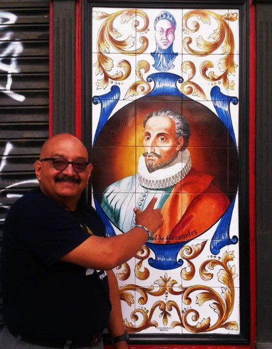 Author Silvio Sirias in front of a depiction of Miguel de Cervantes in Madrid.