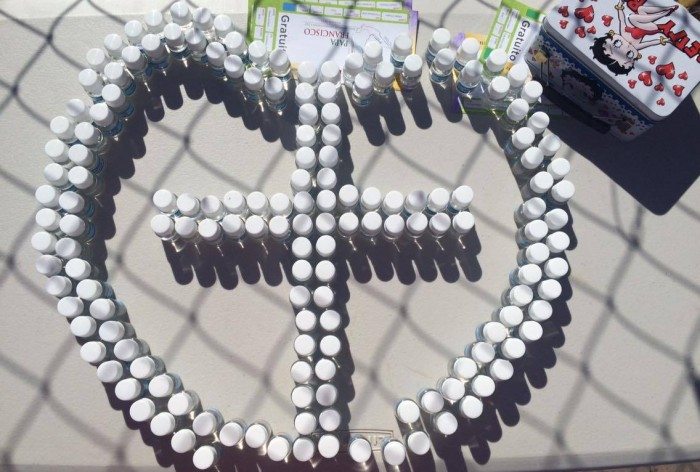 A heart and cross made from small, holy water bottles atop a puesto (Maria Esquinca)